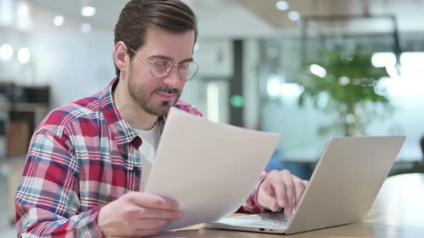 Designer Masculino Grave trabalhando em Laptop com Documentos — Vídeo de Stock