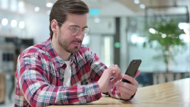 Diseñador masculino molesto que tiene pérdida en el teléfono inteligente — Vídeo de stock