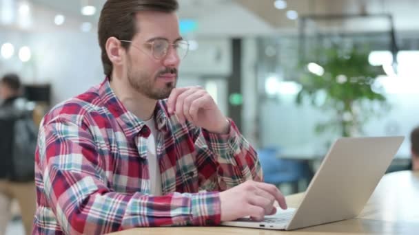 Pensive Male Designer Denken en Werken op Laptop — Stockvideo