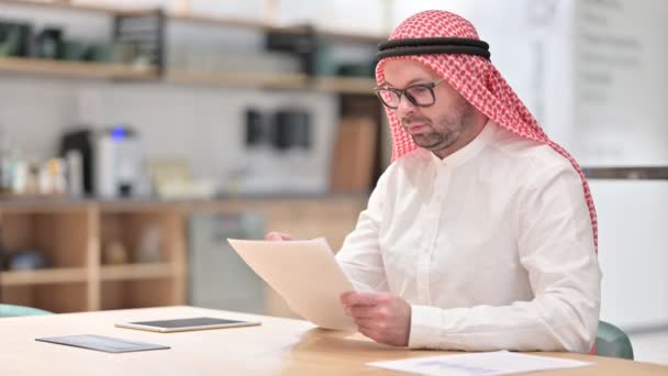 Jonge Arabische man die documenten aan het lezen is — Stockvideo