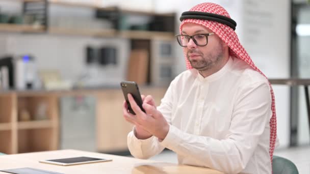 Hombre árabe joven usando Smartphone en la oficina — Vídeos de Stock