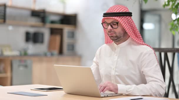 Seriózní mladý arabský muž pracující na notebooku v kanceláři — Stock video