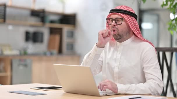 Kranker junger arabischer Mann mit Laptop hustet im Büro — Stockvideo
