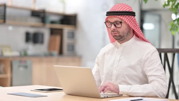 Sério jovem árabe homem com laptop olhando para a câmera — Vídeo de Stock