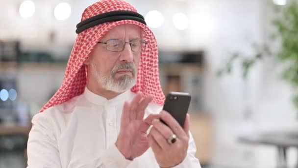 Старый арабский бизнесмен с помощью смартфона, текстовых сообщений — стоковое видео