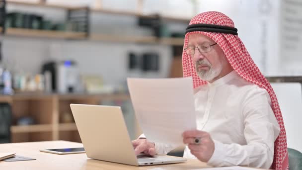 Старый арабский бизнесмен, работающий на вершине и догматах — стоковое видео