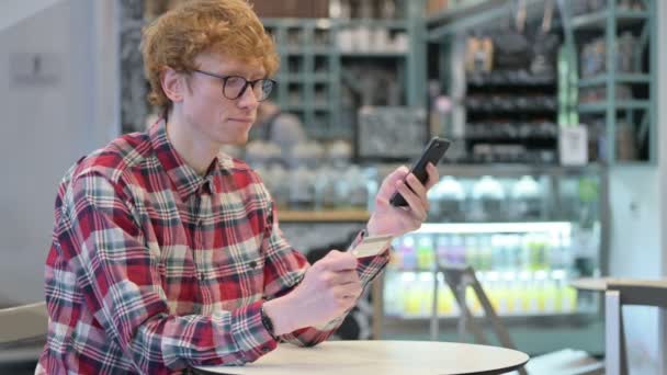 El éxito de compras en línea de pago en Smartphone por Redhead Man — Vídeo de stock