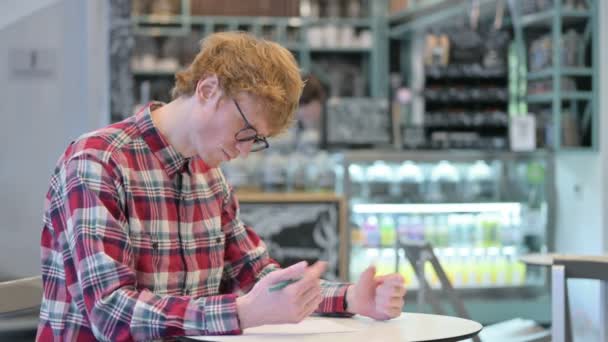 紙に書こうとする若い赤毛の男、失敗 — ストック動画