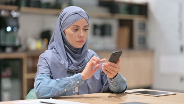 Perempuan Arab muda Merayakan Sukses di Smartphone di Kafe — Stok Video