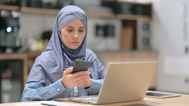 Arabisk kvinne bruker Smartphone og Laptop på arbeidsplassen – stockvideo