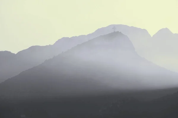 Evening landscape with silhouette of mountains in fog