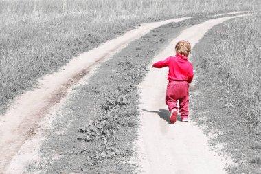 Büyüyen çocukların ve çocukların yetişkin olma arzusunun sembolü olarak çimler arasında yol boyunca uzaklığa kaçan arkadan soyut fotoğraf