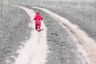 Büyüyen çocukların ve çocukların yetişkin olma arzusunun sembolü olarak çimler arasında yol boyunca uzaklığa kaçan arkadan soyut fotoğraf