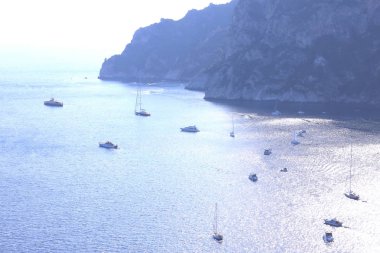 İyi güneşli havalarda dağların arka planına karşı yaz aylarında deniz koyunda birkaç yat