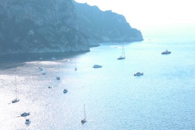 İyi güneşli havalarda dağların arka planına karşı yaz aylarında deniz koyunda birkaç yat