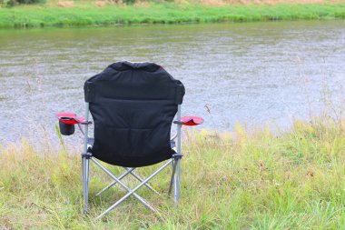 Nehir yakınındaki parkta sonbaharda Turist sandalye