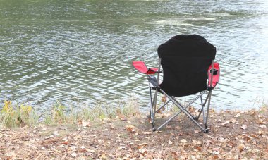 Nehir yakınındaki parkta sonbaharda Turist sandalye