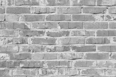 Üzerinde farklı dokulara sahip eski tuğlalardan yapılmış duvar resmi olan siyah beyaz bir fotoğraf.