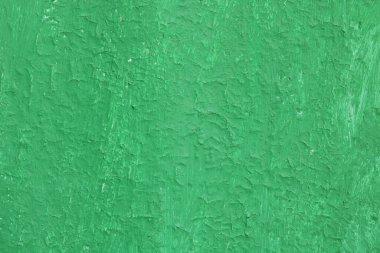Eski, pürüzlü bir yüzeyi olan eski yeşil boyalı, eski ve pürüzlü bir yüzeyde yeşil rengin çizgileri ve pürüzlü dokusuna sahip güzel, eski yeşil bir arka plan.