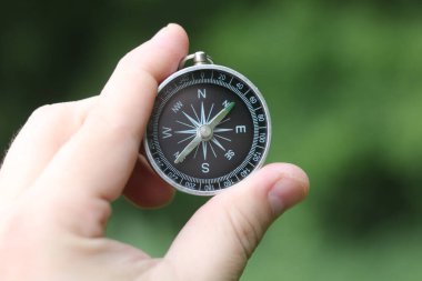 Pusula ile turizmin, pusula ile seyahat etmenin ve pusula ile açık hava aktivitelerinin sembolü olarak, doğal arka planda eski klasik navigasyon pusulası bulunmakta