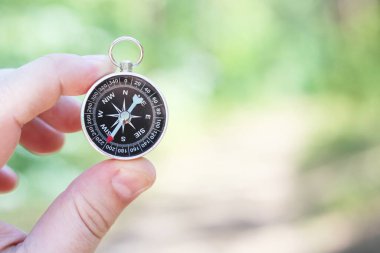 Pusula ile turizmin, pusula ile seyahat etmenin ve pusula ile açık hava aktivitelerinin sembolü olarak, doğal arka planda eski klasik navigasyon pusulası bulunmakta