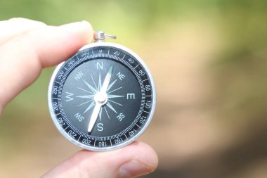 Pusula ile turizmin, pusula ile seyahat etmenin ve pusula ile açık hava aktivitelerinin sembolü olarak, doğal arka planda eski klasik navigasyon pusulası bulunmakta
