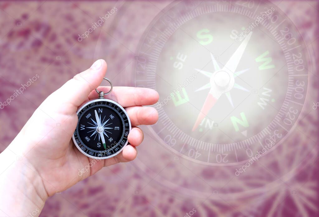 round compass in hand on abstract background as symbol of tourism with compass, travel with compass and outdoor activities with compass