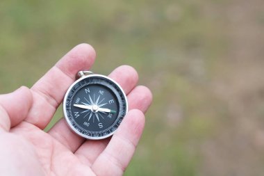 Pusula ile turizmin, pusula ile seyahat etmenin ve pusula ile açık hava aktivitelerinin sembolü olarak, doğal arka planda eski klasik navigasyon pusulası bulunmakta
