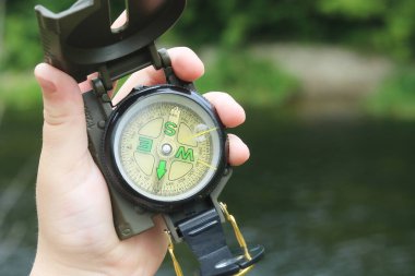 Pusula ile turizmin, pusula ile seyahat etmenin ve pusula ile açık hava aktivitelerinin sembolü olarak, doğal arka planda eski klasik navigasyon pusulası bulunmakta