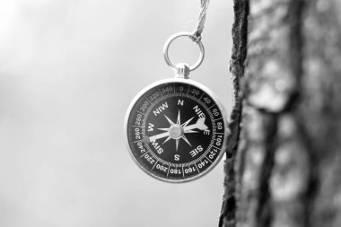 Pusula ile turizmin sembolü olarak eski tarz yuvarlak pusulanın siyah ve beyaz fotoğrafı, pusula ile seyahat ve pusula ile açık hava aktiviteleri