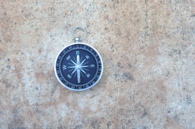 Pusula ile turizmin sembolü olarak soyut arka planda yuvarlak pusula, pusula ile seyahat ve pusula ile açık hava aktiviteleri