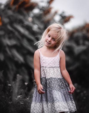 Ayçiçekli bir tarlada elbise giymiş güzel sarışın kız.