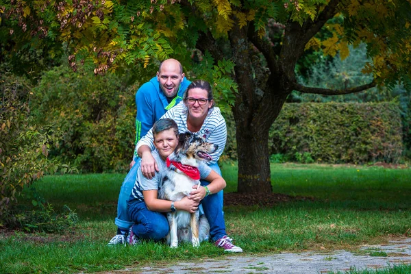 young family with dog hugging each other