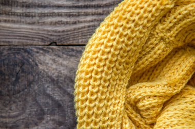 ahşap arka plan üzerinde rulo sarı örme atkı