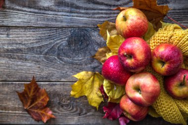 ahşap arka plan üzerinde kırmızı elma sarı sonbahar örgü yapraklar