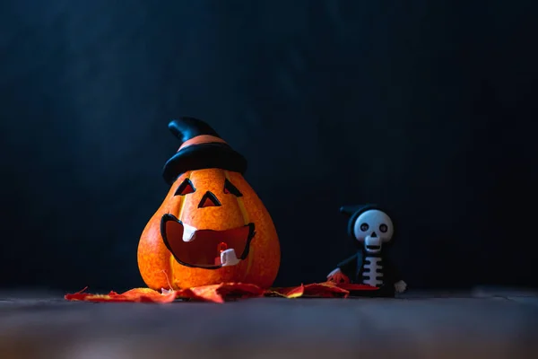 pumpkin in a hat with a face and a skeleton in a hoodie