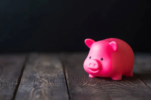 pink pig piggy Bank on wooden dark background