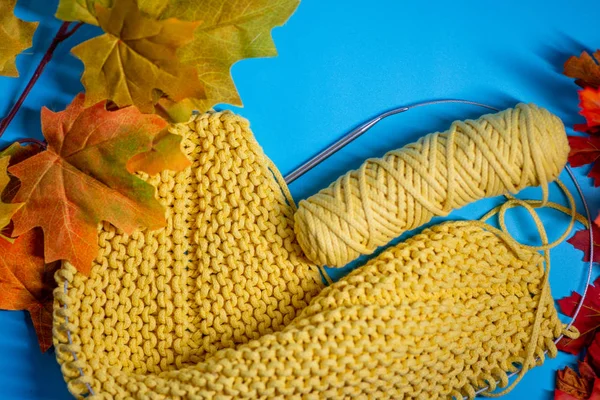 Yellow knitting with autumn leaves — Stock Photo, Image