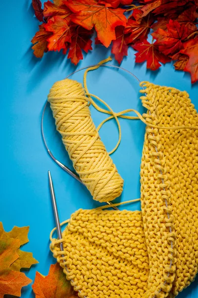 Yellow knitting with autumn leaves — Stock Photo, Image