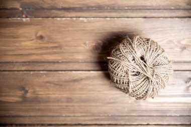 Tahta arka planda sert bir iplik yumağı.