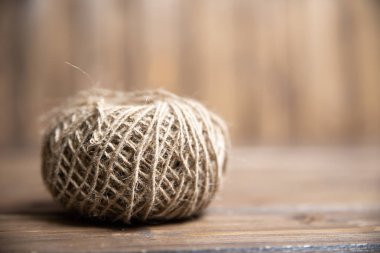 Tahta arka planda sert bir iplik yumağı.