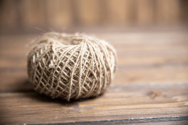 Tahta arka planda sert bir iplik yumağı.