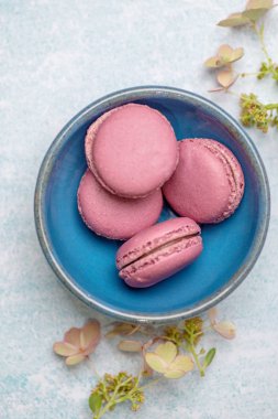 Mavi bir tabakta pembe kurabiyeler.