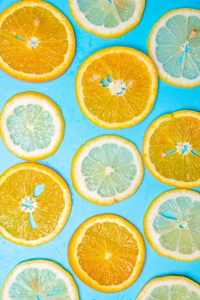 slices of lemons and oranges on a blue background