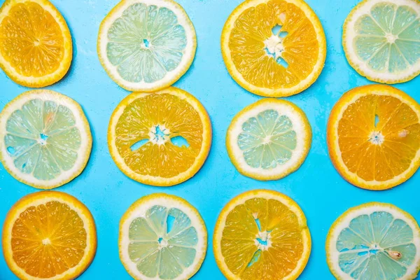 slices of lemons and oranges on a blue background