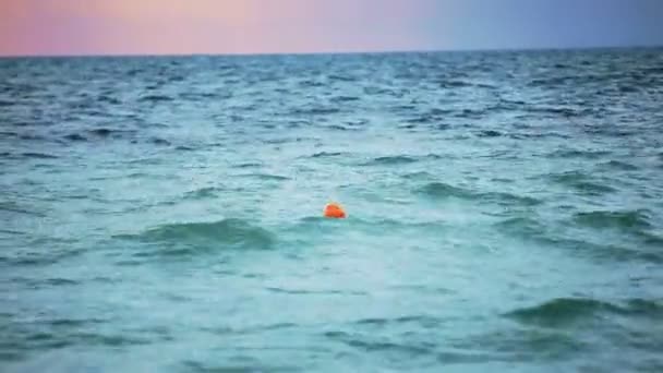 Boa arancione galleggia nel mare. Nuvoloso . — Video Stock