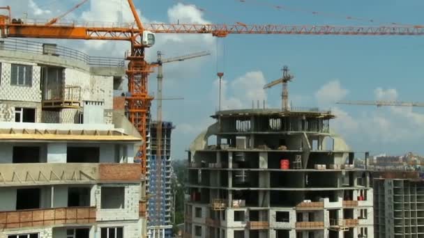 Movimento panorâmico. Construindo guindastes arranha-céus edifícios altos Projetos de cidade — Vídeo de Stock