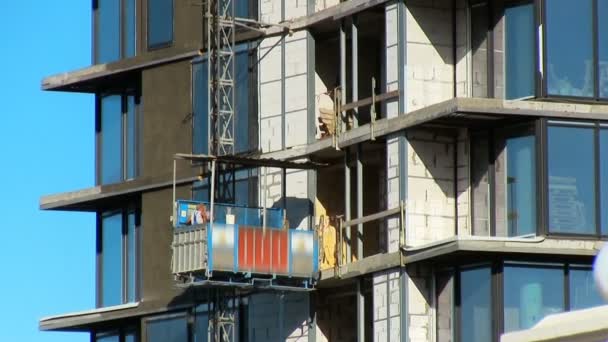 Construção arranha-céus de edifícios altos O construtor sobe no elevador — Vídeo de Stock