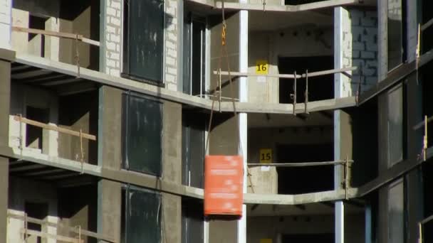Construcción rascacielos de gran altura Grúa eleva materiales de construcción consumibles Lana de vidrio de cemento — Vídeo de stock
