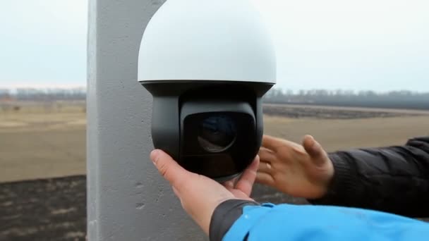 Dois homens Um eletricista conserta instala um sistema de vigilância por vídeo — Vídeo de Stock